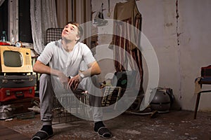 Sitting Young Man at Junked Room Looking Up