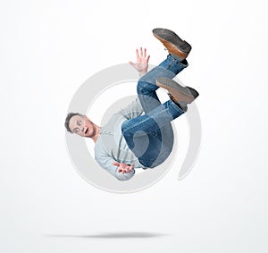 Situation, the man in casual clothes is falling down on light background. Concept of an accident