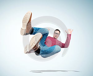Situation, the man in casual clothes and glasses is falling down. Concept of an accident photo