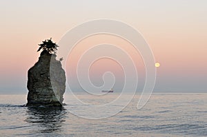Siwash rock at moonset photo