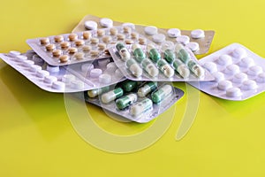 Six blisters of generic tablets on yellow background photo