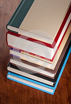 Six books stacked neatly on a table