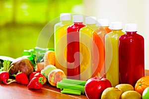 Six bottles of delicious organic juice standing in a row sorrounded by fruits and veggies, beautiful colors