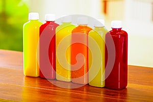 Six bottles of organic juice standing in a row, beautiful colors and refreshing design