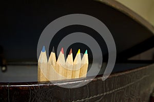 Six colored pencils in old suitcase