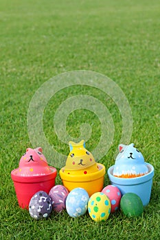 Six eggs and three rabbits on vertical grass background.