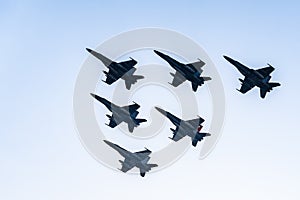 Six F18 Hornet jet fighters flying a blue sky day