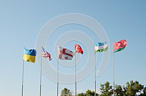 Six flags against a blue sky.
