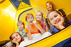 Six funny children having fun in a tent