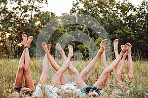 Six girls lie on the grass and raise their legs up