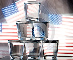 Six glasses stacked by a tower on a multi-colored background