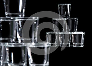 Six glasses stacked by a tower on a multi-colored background