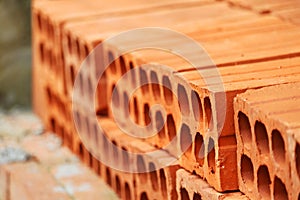 Six-hole bricks made of clay, stacked to be used for construction photo