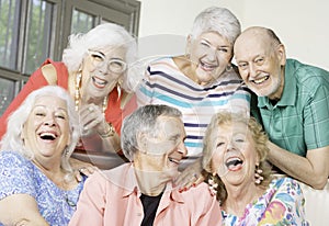 Six Laughing Senior Friends in a living room photo