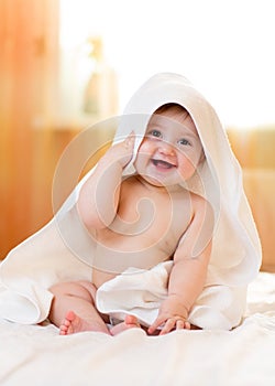 Six month baby girl with towel after bathing