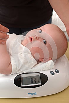 Six month old baby being weighed