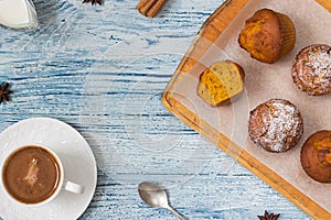 Pumpkin muffins on light blue background with ingredients