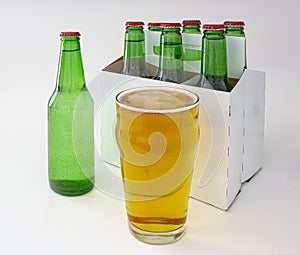 A six pack of pilsner beer with a full pint of beer