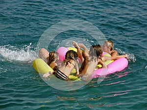 Six people in the crowd on beach toys on sea