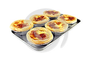 Six piece golden egg tart in foil paper cup on old rectangle aluminum baking tray for small oven isolated on white background