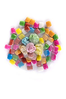 Six pieces of chewed bubble gum surrounded by unchewed squares top down view