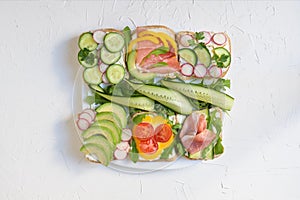 Fresh sandwich with avocado, radish, cucumber, raw ham, pepper and fresh cheese, summer healthy snack