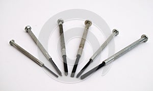 Six screwdrivers rigged in some form on a white background