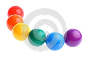 Six shiny coloured plastic toy balls in row