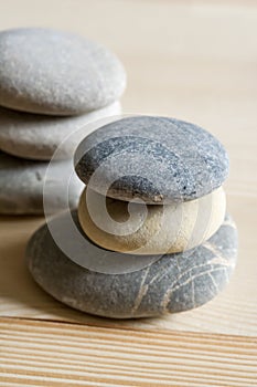 Six spa zen stones stacked on a wood background