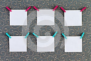 Six square tags with clothespins attached