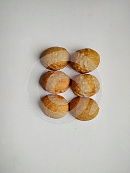 Six walnut shells on a white background