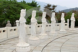 Six white marble Buddha statues in a natural ambiance, China photo