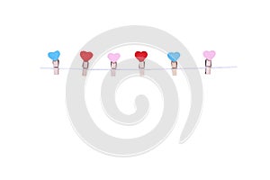 Six wooden clothes pins in heart shape patterns hanging on white rope isolated on white background , clipping path