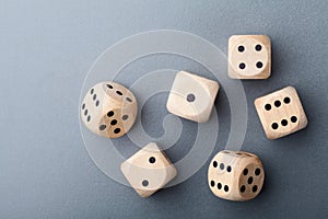 Six wooden dice on gray table top view. Board game. Gambling devices.