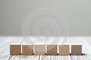 Six wooden toy cubes on grey wooden background