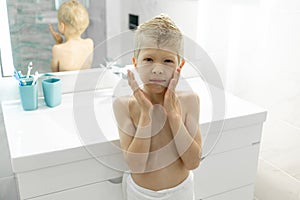 Six-year-old boy applies aftershave like dad in the morning in the bath, hygiene in the morning