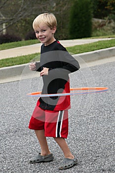 Six year old boy exercising with a hula hoop