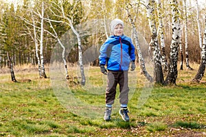 Six-year-old boy jumping on the green grass