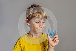 Six-year old boy shows myofunctional trainer. Helps equalize the growing teeth and correct bite, develop mouth breathing photo