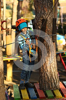 Six year old boy surmounting obstacle course in the rope park photo