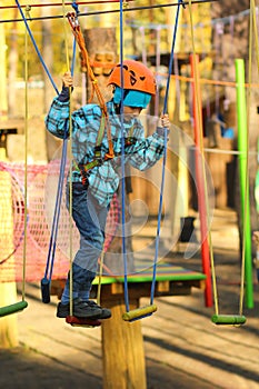 Six year old boy surmounting obstacle course in the rope park photo