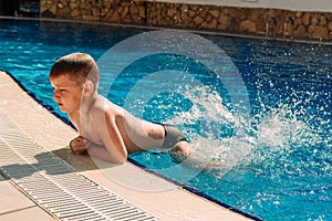 Six-year-old boy swimming in the outdoor pool at the hotel