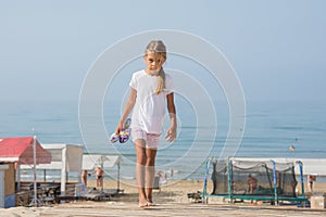 Six year old girl walking on wooden flooring from the sea home