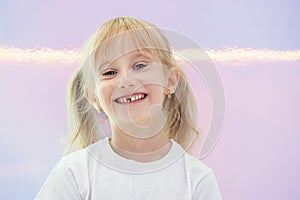 Six year smiling happy girl holding a first fallen tooth and looking at him.