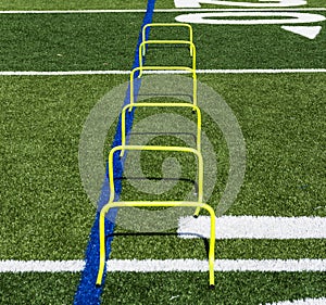 Six yellow mini hurdles set up on a field