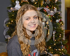 Sixteen yearold girl with a big smile posing in front of her Christmas tree in her home in Saint Louis, Missouri.