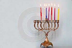 Sixth day of Hanukkah with burning Hanukkah colorful candles in Menorah.Chanukkah-jewish holiday.