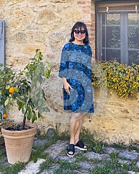 Sixty-five year-old female Korean tourist posing at the Poder Spedalone near Montepulciano, Italy. photo