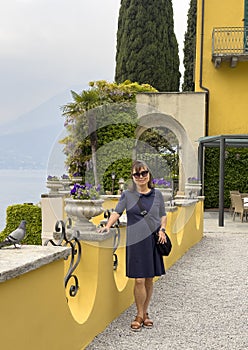 Sixty-five year-old female Korean tourist on a terrace in Varenna, Italy, on Lake Como.