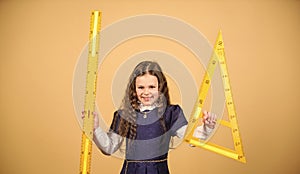 Sizing and measuring. Pupil cute girl with big ruler. School student study geometry. Kid school uniform hold ruler. I